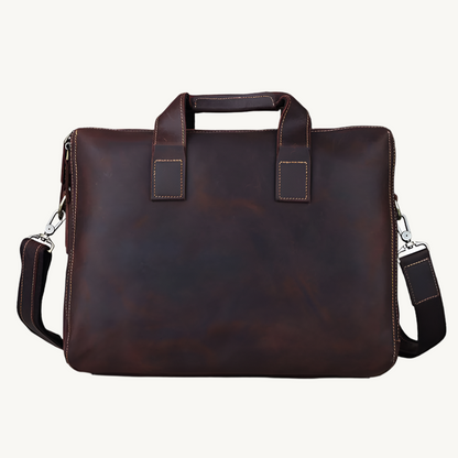 Brown leather briefcase with shoulder strap on a white background